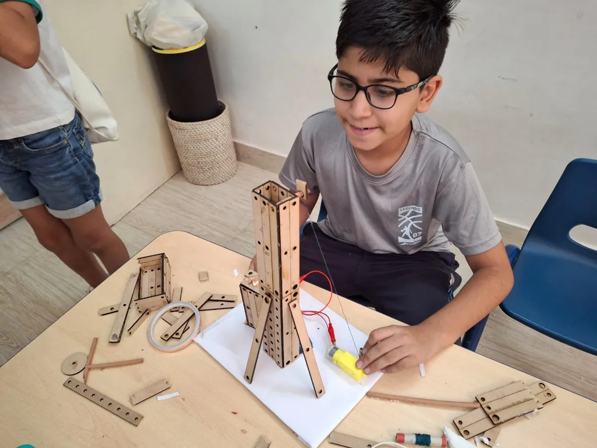 Child building a motorised wooden tower
