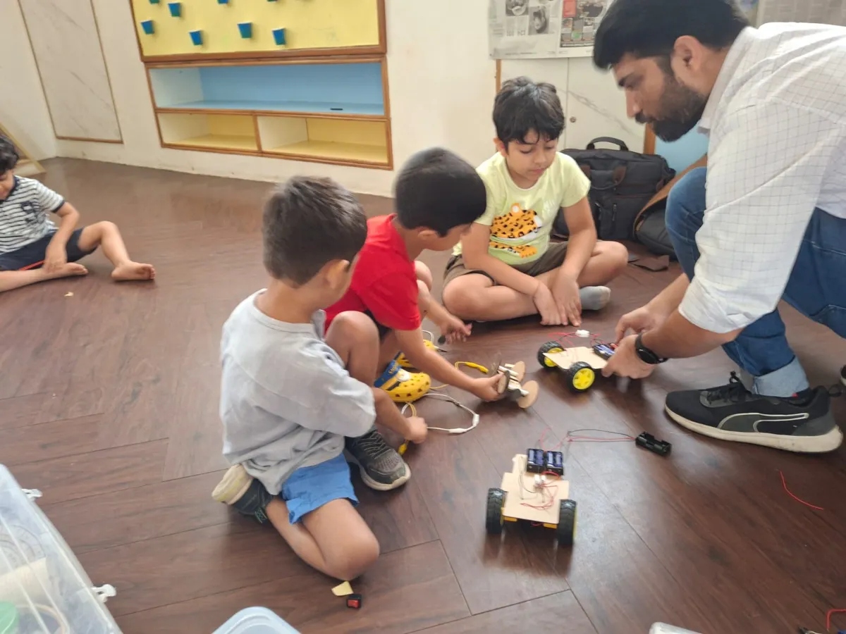 Children testing their robot cars with a facilitator at an Innovator Saturday class